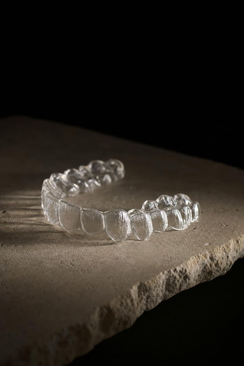 A clear aligner on pale stone
